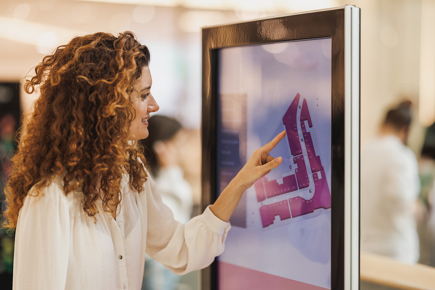Woman using digital wayfinding kiosk
