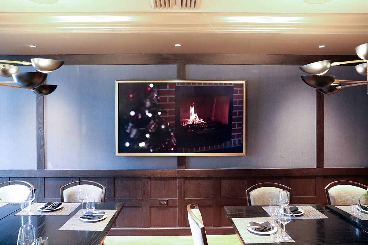 Digital screen displaying a fireplace in 9 Prime dining area
