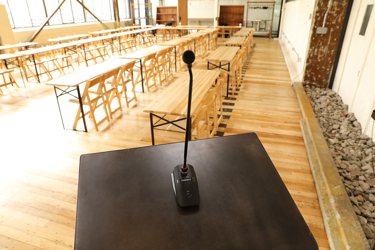 Mic stand overlooking room with wooden tables and chairs