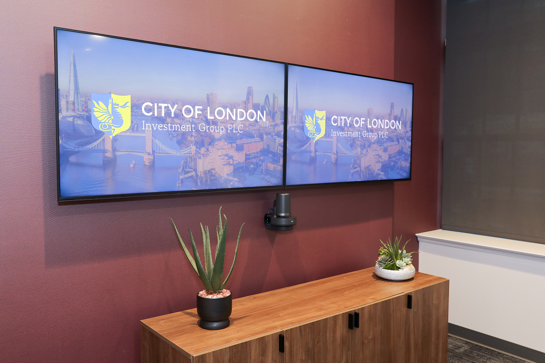 Dual TV screens with PTZ camera mounted on the wall underneath